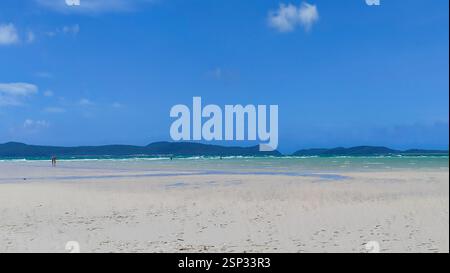 Ein paar Spaziergänge Hand in Hand am idyllischen weißen Sandstrand von Hamilton Island, türkisfarbenes Wasser am Ufer. Das Paradies liegt im Herzen o Stockfoto