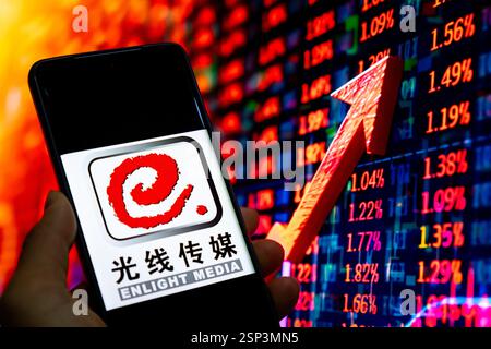CHONGQING, CHINA - 14. FEBRUAR 2025 - eine Illustration zeigt das Enlight Media Logo auf einem Smartphone mit einem Aktienanstiegsdiagramm im Hintergrund Stockfoto