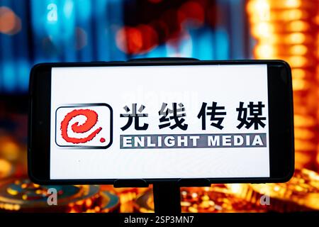 CHONGQING, CHINA - 14. FEBRUAR 2025 - eine Illustration zeigt das Enlight Media Logo auf einem Smartphone mit einem Aktienanstiegsdiagramm im Hintergrund Stockfoto