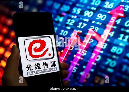 CHONGQING, CHINA - 14. FEBRUAR 2025 - eine Illustration zeigt das Enlight Media Logo auf einem Smartphone mit einem Aktienanstiegsdiagramm im Hintergrund Stockfoto