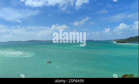 Kleines Boot auf einem tropischen Meer mit weißem Sandstrand und türkisfarbenem Wasser. Es ist eine friedliche tropische Szene, die auf einen möglichen Urlaub hindeutet Stockfoto