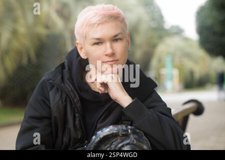 Ziemlich reife Frau, die auf einer Parkbank sitzt Stockfoto