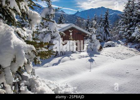 Winterlandschaft in alpinem französischem Berg bedeckt mit Schnee unter blauem Himmel und schneebedecktem Chalet in Tannen Stockfoto
