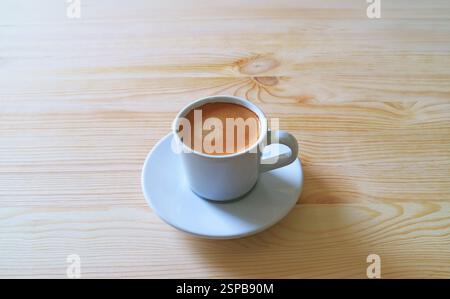 Tasse aufschäumenden Espresso-Kaffee isoliert auf Holztisch Stockfoto