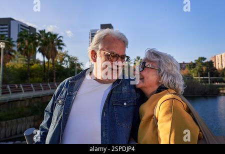 Glückliches Seniorenpaar, das einen romantischen Spaziergang im Stadtpark genießt. Stockfoto