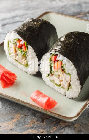 Huhn Sushi Burrito oder Sushhirrito ist eine Art japanischer mexikanischer Fusionsküche aus der Nähe auf dem Teller auf dem Tisch. Vertikal Stockfoto