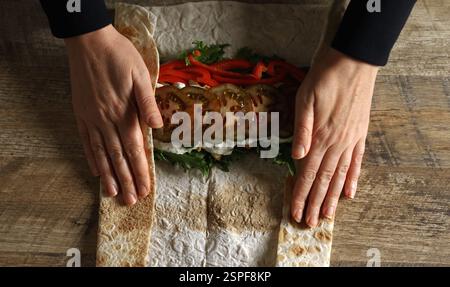 Schawarma in Lavash mit Huhn und Gemüse einwickeln. Stockfoto