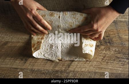 Schawarma in Lavash mit Huhn und Gemüse einwickeln. Stockfoto