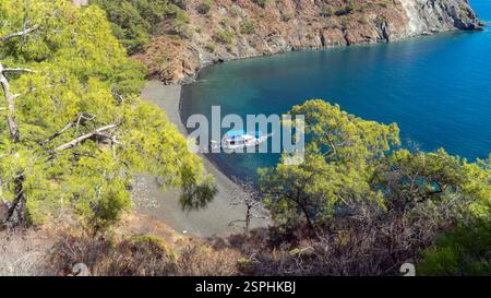 Antalya, Türkei - 5. Oktober 2024: Ein Segelboot an der atemberaubenden türkischen Mittelmeerküste in Antalya. Blaues Meer, umgeben von üppig grünen Wäldern und Teppichen Stockfoto