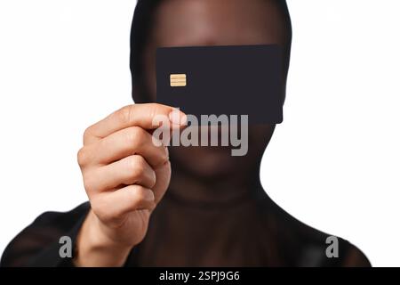 Internet-Dieb in schwarzer Maske mit schwarzer Kreditkarte in der Hand Stockfoto