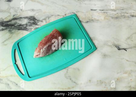 Ein Stück Schweinefleisch auf einem Brett von oben. Fleisch zum Kochen von rotem Fleisch. Stockfoto