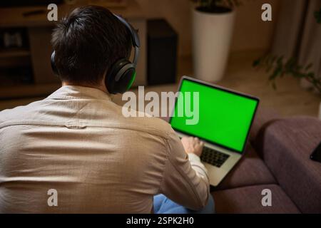 Freiberuflicher Mann, der zu Hause auf dem Sofa am Laptop arbeitet, von zu Hause aus arbeitet Stockfoto