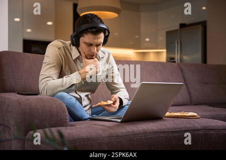 Freelancer gestresster Mann leiden unter Kopfschmerzen und arbeiten mit Laptop zu Hause Stockfoto