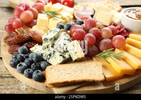 Verschiedene Arten von köstlichem Käse und anderen Snacks auf Holztisch, Nahaufnahme Stockfoto