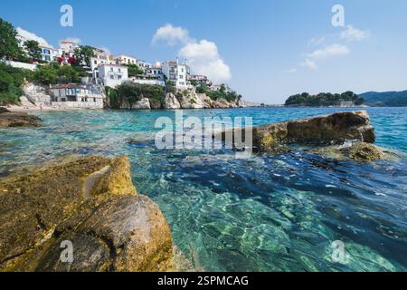 Eine ruhige Szene eines wunderschönen mediterranen Dorfes an der Küste mit kristallklarem Wasser im Vordergrund Stockfoto