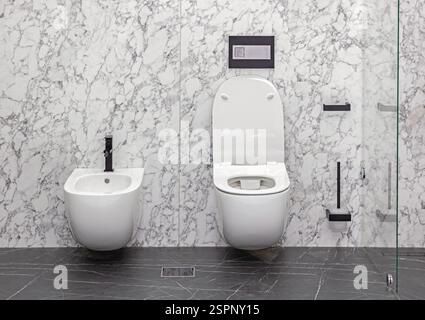 Wandmontiertes weißes Keramikbidet und Toilettenschüssel im Marmorbad Stockfoto