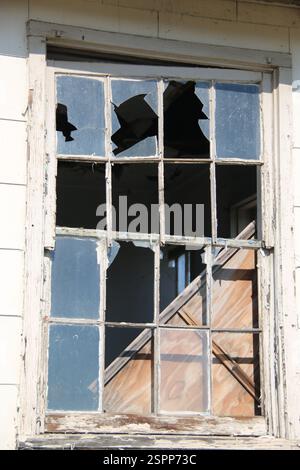 Kaputte Fenster in einem alten verlassenen und verwüsteten Gebäude. Stockfoto