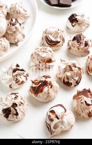 Schokoladen-Meringue-Kekse auf weißem Backpapier. Nahansicht Stockfoto
