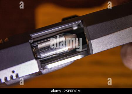 Eine Kugel des Kalibers .45 ACP wird vorbereitet, um in eine halbautomatische Pistole gekampft zu werden. Stockfoto