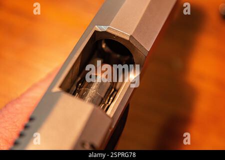 Eine Kugel des Kalibers .45 ACP wird vorbereitet, um in eine halbautomatische Pistole gekampft zu werden. Stockfoto