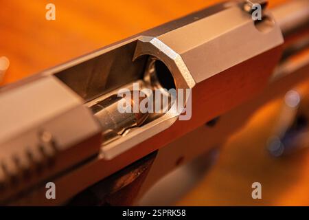 Eine Kugel des Kalibers .45 ACP wird vorbereitet, um in eine halbautomatische Pistole gekampft zu werden. Stockfoto