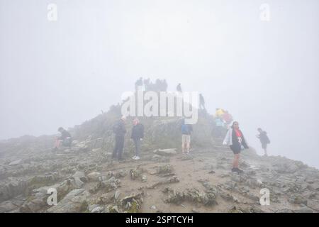 Wales, Gwynedd, Snowdonia - 09. Juli 2024: Besucher auf Mount Snowdon an einem nebeligen Tag. Stockfoto