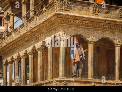 Kathmandu, Nepal - 11. Februar 2025 - ein nepalesischer Mann hoch oben auf einem kunstvollen traditionellen buddhistischen Tempel Stockfoto