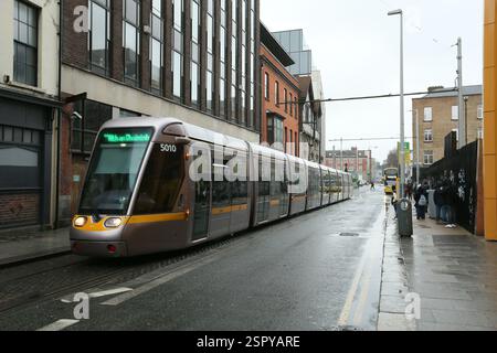 Dublin, Irland - 14. Februar 2025 - eine grüne Linie, die Luas an einem nassen Tag mit starkem Regen die Hawking Street hinunterzieht Stockfoto