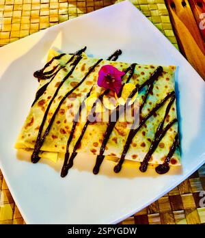Banane mit Schokoladensauce auf einem weißen Teller Stockfoto