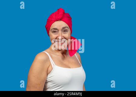 Porträt einer lächelnden Reifen Frau mit rotem Kopftuch, das Wellness, Kraft und Positivität repräsentiert Stockfoto