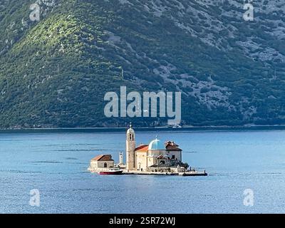 Bucht von Kotor, Montenegro - 2. Juli 2024: Insel Perast mit Kirche unserer Lieben Frau von Skrpjela. Weite Landschaft mit nordwestlicher Küstenlinie der Bucht Stockfoto
