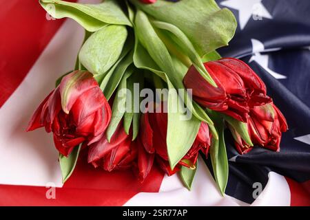 Wunderschöne Tulpenblumen und die Flagge der USA, Nahaufnahme. Gedenkfeier Stockfoto