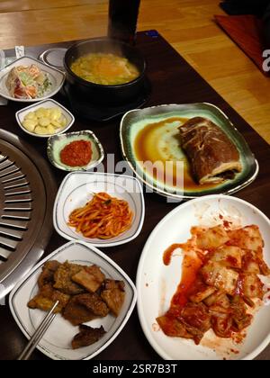 Koreanisches Grillfest. Herzhaftes Grillfleisch, lebhafte Beilagen, dampfende heiße Suppe. Eine Feier der Aromen, der Texturen. Visuelle Darstellung koreanischer cu Stockfoto