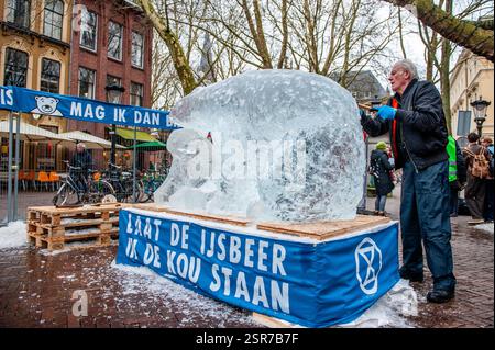 Utrecht, Niederlande. Februar 2025. Der niederländische Künstler Frank de Conynck arbeitet an der Eisskulptur. Die klimaaktivistische Organisation Extinction Rebellion platzierte die Eisskulptur eines Eisbären mitten in der Stadt, um die globale Erwärmung zu symbolisieren. (Foto: Ana Fernandez/SOPA Images/SIPA USA) Credit: SIPA USA/Alamy Live News Stockfoto