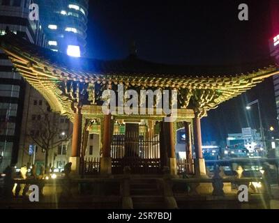 Pavillon: Beleuchtete Struktur mit kunstvollem Dach und lebhaften Farben. Traditionelle koreanische Architektur, die Schönheit und Erbe symbolisiert. Auch ein Collabori Stockfoto