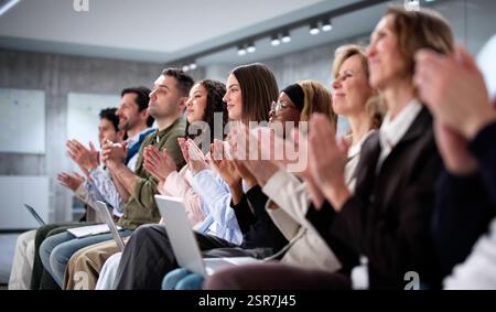 Klug gekleidetes Publikum aus verschiedenen Geschäftsleuten, die beim Seminar applaudieren. Stockfoto