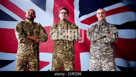Soldat Gegen Die Britische Flagge, Vertritt Einheit Und Ehre. Eine Multirassische Gruppe Verschiedener Militäroffiziere Steht Patriotisch Zusammen. Stockfoto