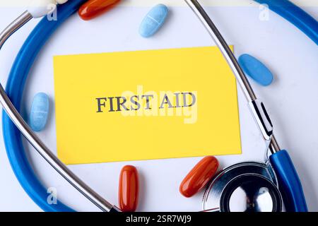 Ein erste-Hilfe-Konzept mit Stethoskop und bunten Pillen unterstreicht die Bedeutung des Gesundheitsbewusstseins am Arbeitsplatz. Stockfoto