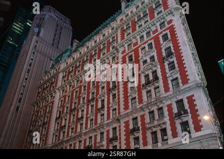 Ein rot-weißes Backsteingebäude, ein klassisches Wahrzeichen in New York, Manhattan, hebt sich vor der Kulisse eines modernen Wolkenkratzers hervor, der die essener stadt einfängt Stockfoto