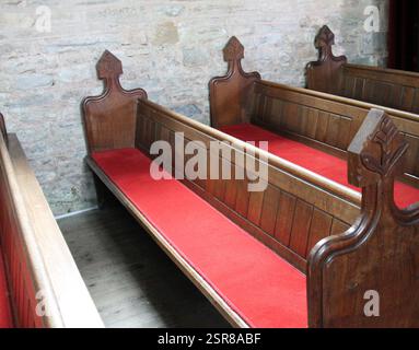 Die hölzernen Bänke an einer kleinen Landkirche. Stockfoto