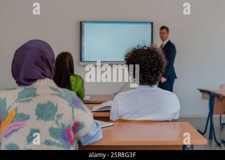 Ein Universitätslehrer, der eine Lektion im Klassenzimmer mit einem Smart Board erklärt. Stockfoto