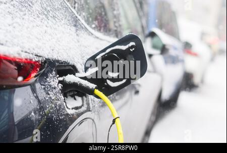 Hannover, Deutschland. Februar 2025. Schnee liegt auf einem Ladekabel, mit dem ein Elektroauto an einer öffentlichen Ladestation bei eisigen Temperaturen aufgeladen wird. Quelle: Julian Stratenschulte/dpa/Alamy Live News Stockfoto