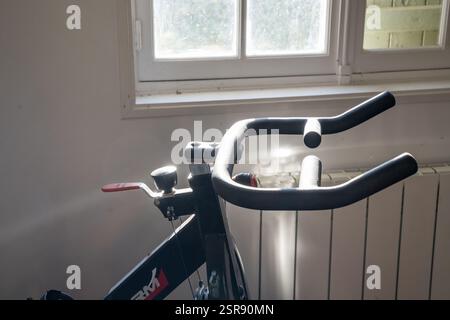Fitnessgeräte warten auf die morgendliche Trainingsroutine in einem sonnendurchfluteten Raum Stockfoto