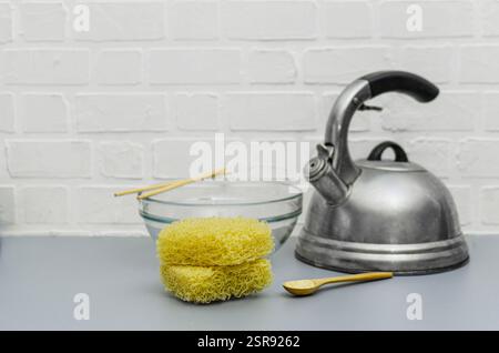 Küchenarbeitsplatte mit verschiedenen Artikeln zum Instant-Nudeln-Kochen. Der Hintergrund besteht aus einer weißen Ziegelwand, die auf den Vordergrund ausgerichtet ist. Stockfoto