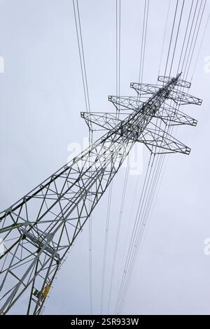 Strommast mit Drähten gegen blauen Himmel Stockfoto