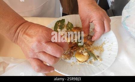 Eine Frau schmückt einen Teller mit der „sikopitarida“, einem traditionellen kretischen Gericht mit getrockneten Feigen, Walnüssen und Honig Stockfoto