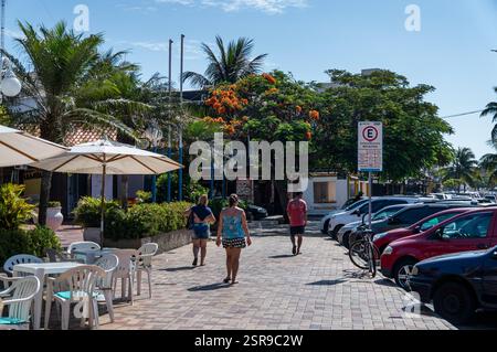 Leute laufen auf dem großen Bürgersteig in der Nähe des Lion Club Bystreet mit Restaurants und geparkten Autos unter heißem Sommernachmittag sonnigen, klaren blauen Himmel. Stockfoto