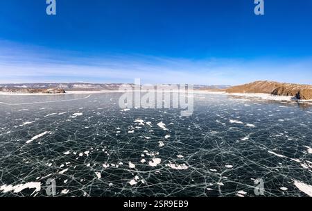 Blick von oben auf den Blue Clear Ice Lake Baikal. Rissüberzug auf gefrorenem Wasser. Kalte Winterlandschaft mit Bergen, sonniger Tag, Natur Stockfoto