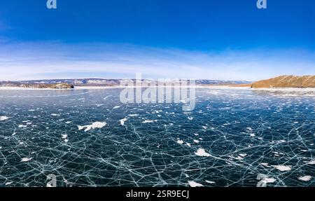 Blick von oben auf den Blue Clear Ice Lake Baikal. Rissüberzug auf gefrorenem Wasser. Kalte Winterlandschaft mit Bergen, sonniger Tag, Natur Stockfoto
