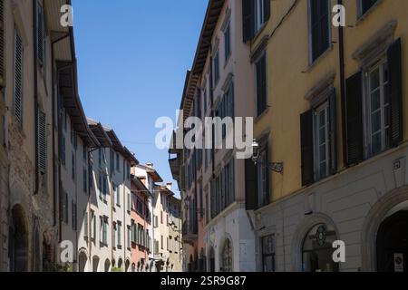 Geschwungene Straße aus rosa und gelben Häusern mit Bögen in der Via Pignolo, Citta Bassa Altstadt, Bergamo, Italien. Stockfoto